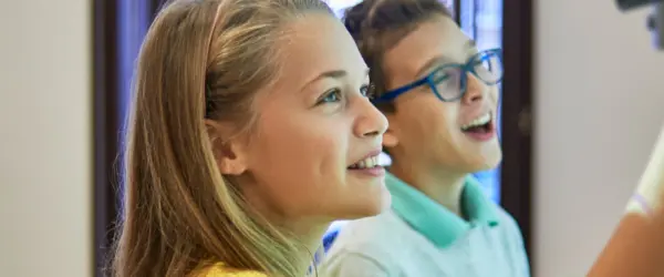 Two students working on a whiteboard together