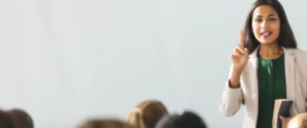 A teacher speaking in front of a classroom of students